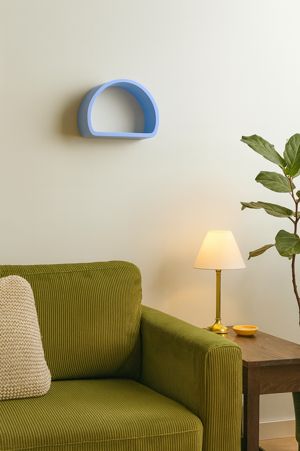 Green sofa with a decorative pillow, blue wall shelf, lamp, and plant in a room.